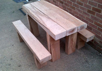 A timber outdoor table made from new red gum sleepers
